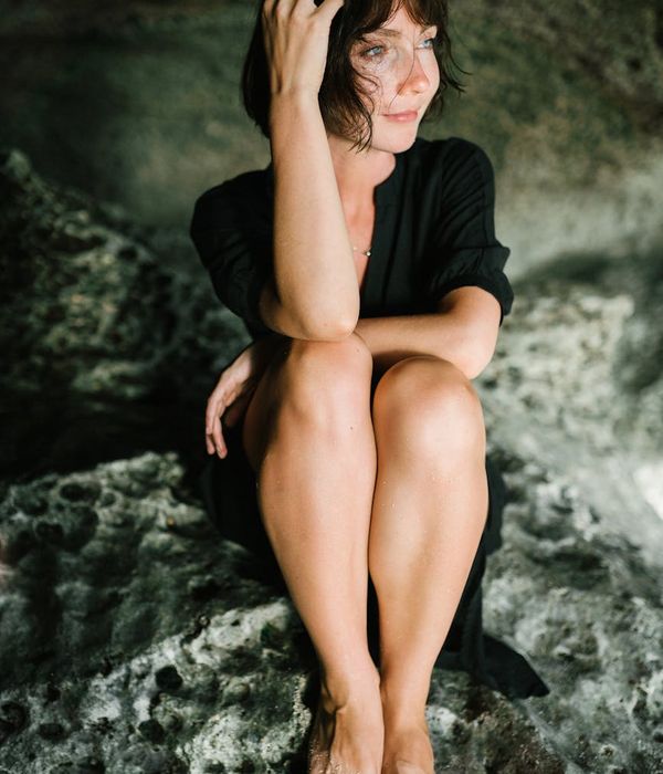 Person sitting in a meditative yoga pose with a serene expression.